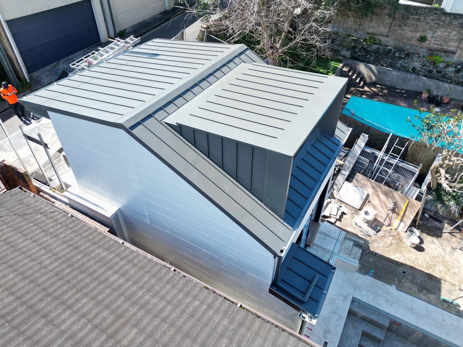 Metal roof installation in progress with scaffolding